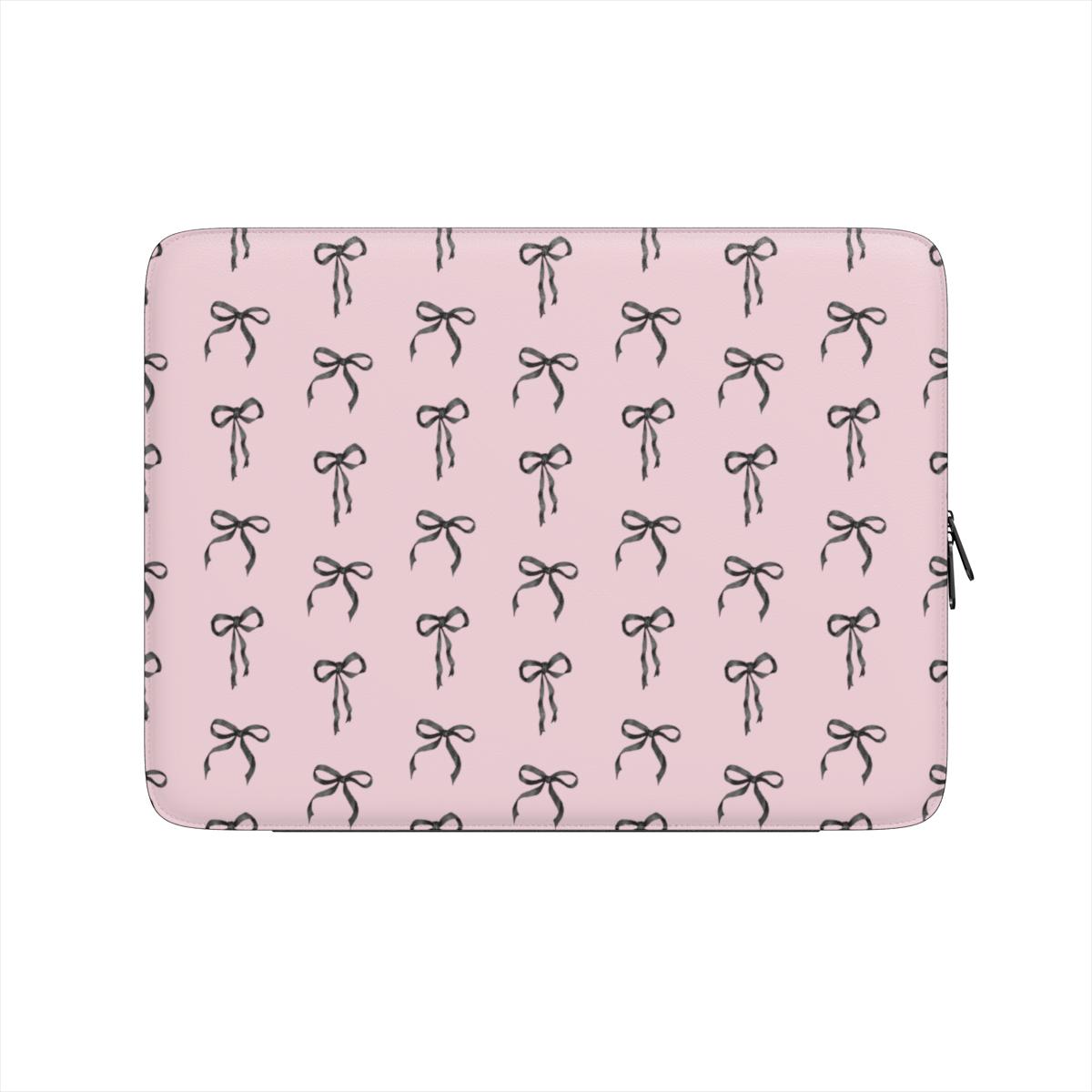 Pink laptop sleeve with black ribbon bow pattern and soft padded protective design