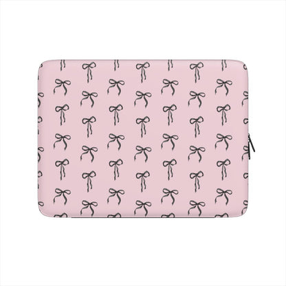 Pink laptop sleeve with black ribbon bow pattern and soft padded protective design