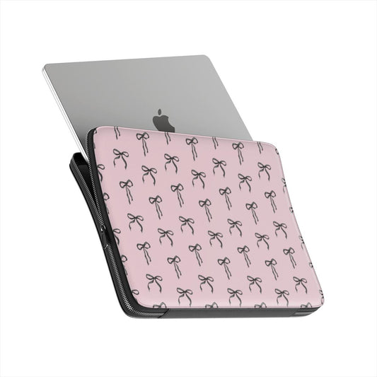 Pink laptop sleeve with black ribbon bow pattern and soft padded protective design