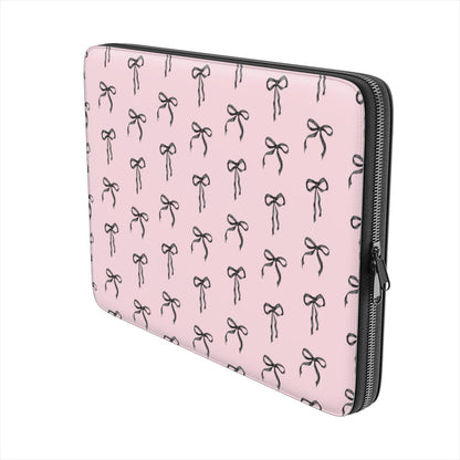 Pink laptop sleeve with black ribbon bow pattern and soft padded protective design