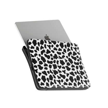 Black and white cow print pattern on Mootique Noir laptop sleeve with modern monochrome aesthetic