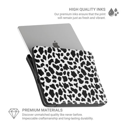 Black and white cow print pattern on Mootique Noir laptop sleeve with modern monochrome aesthetic