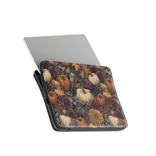 Autumn Garden laptop sleeve with cream pumpkins, burgundy flowers and trailing foliage on a dark botanical background.