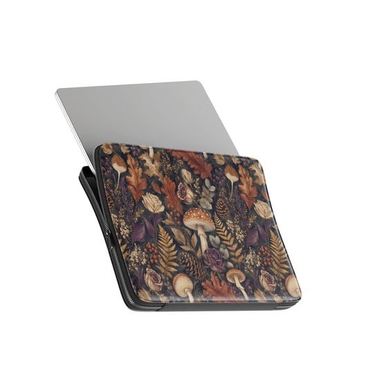 Woodland Forage laptop sleeve with mushrooms, ferns, pinecones and botanical foliage on a dark woodland background.