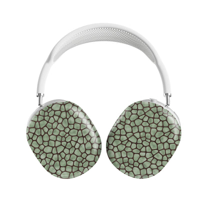 Mossy Mosaic AirPods Max Covers with sage green giraffe spots outlined in chocolate brown from the Wild Atelier collection.