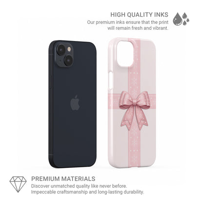 Blush pink ribbon crossing with large satin bow and white snowflakes on a soft pastel background, Protective Phone Case By Case & Charm “Winter’s Gift”