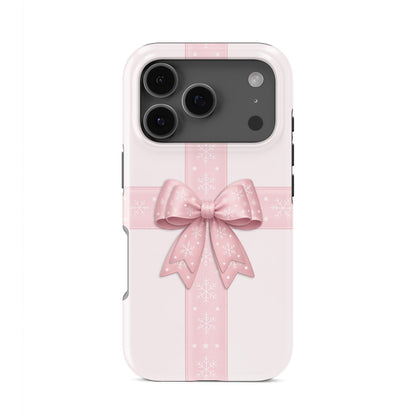 Glossy tough phone case with blush ribbon and large pink bow with white snowflakes on a soft pastel background, Case & Charm Winter’s Gift design
